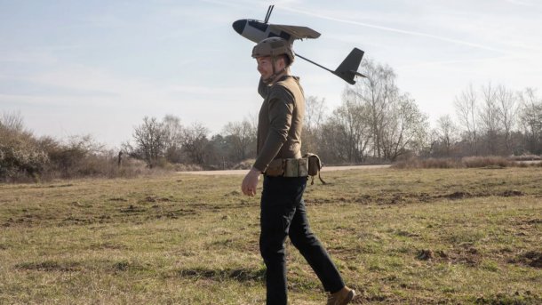 A soldier launches a reconnaissance drone from his hand.