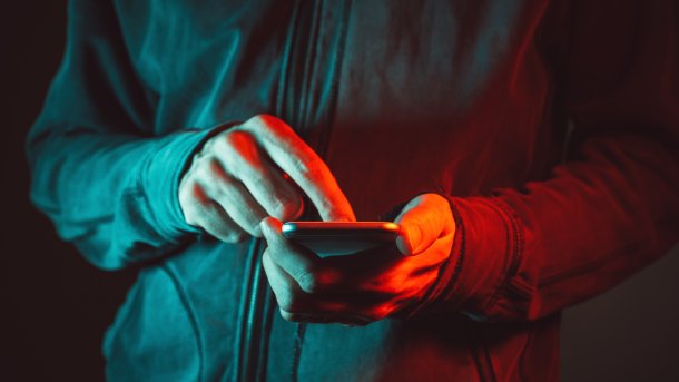 Hands on the smartphone, everything shrouded in red light