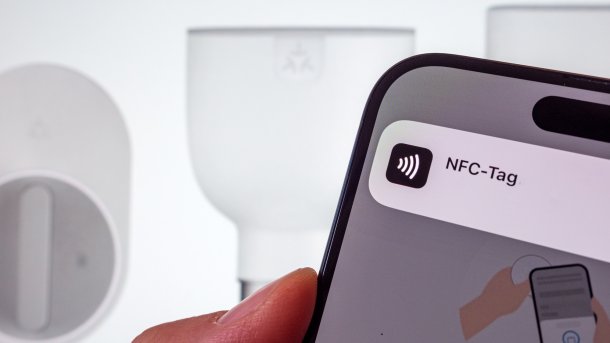 NFT logo on cell phone in front of lamps