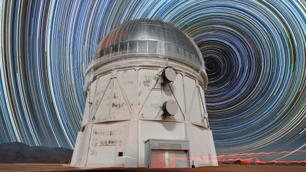 Kreisförmige Sternenspuren über einem Teleskop