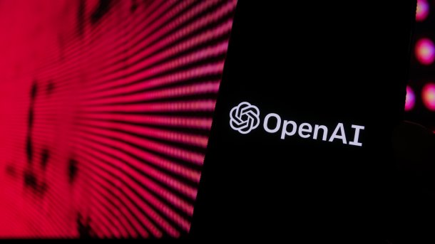Logo und Name von OpenAI auf einem Smartphone, im Hintergrund enorm vergrößtere rote Pixel