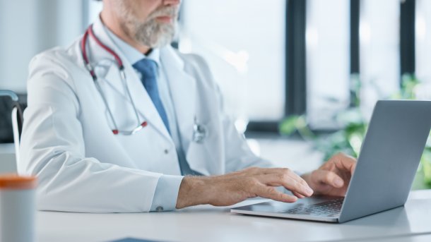 Doctor in a practice on a laptop.