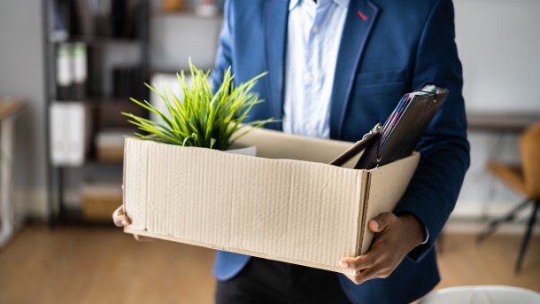 Dismissed employee with belongings in paper box