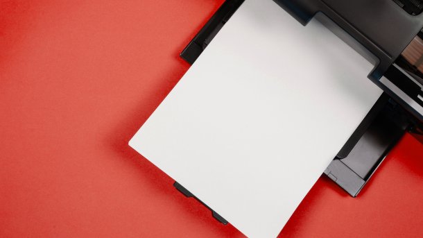 Ein Drucker mit einer weißen Papierseite, von oben fotografiert