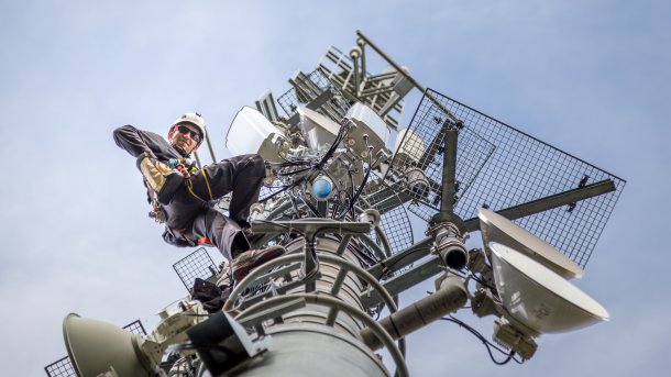 Worker on mobile phone mast