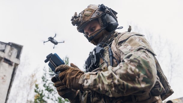 Soldier controlling drone in the sky with smartphone