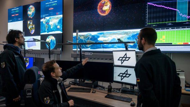 Man points to screens in The Space Situation Center in Uedem
