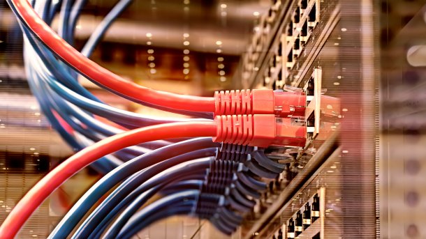 Red and blue Ethernet cables are connected to a rack