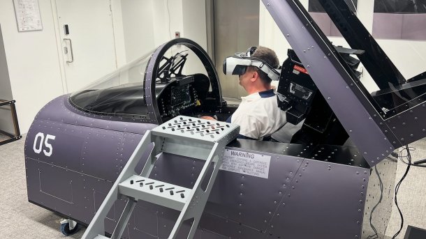 Ein Mann sitzt mit Varjo XR-4 in der Cockpitreplik eines Kampfjets.