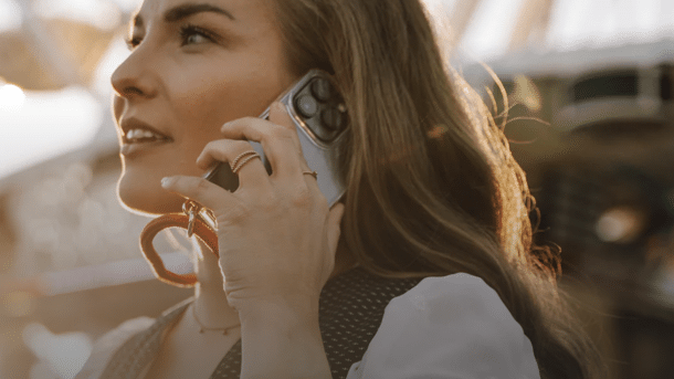 Frau mit iPhone, das in einer Lanyard-Hülle steckt