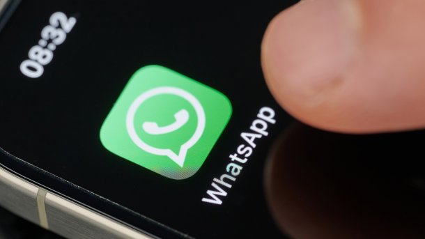 Finger points to Whatsapp icon on a smartphone screen