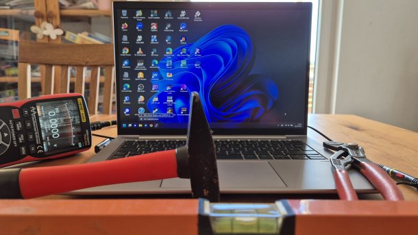 Tools and oscilloscope/multimeter around Windows 11 laptop