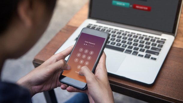 Nutzer mit Handy am Notebook