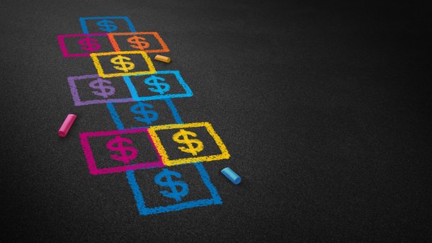 A hopscotch game was drawn on the floor with coloured chalk. There are no numbers in the jumping boxes, but dollar signs. 
