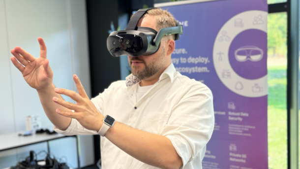 A man with VR glasses moves his hands in front of his face.