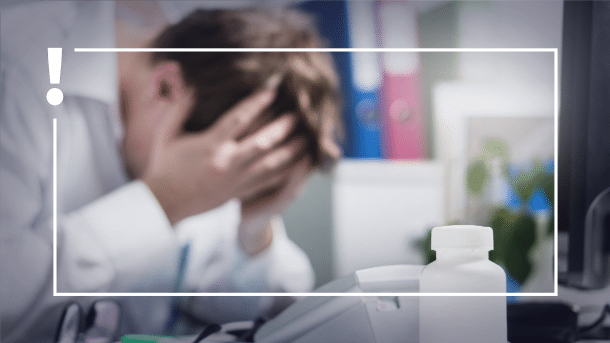 Arzt rauft sich verzweifelt die Haare am Arbeitsplatz
