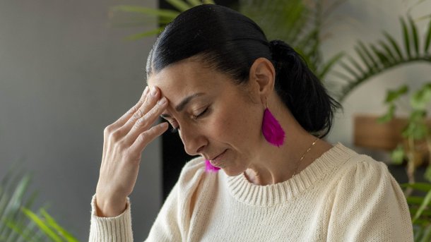 A woman grabs her forehead