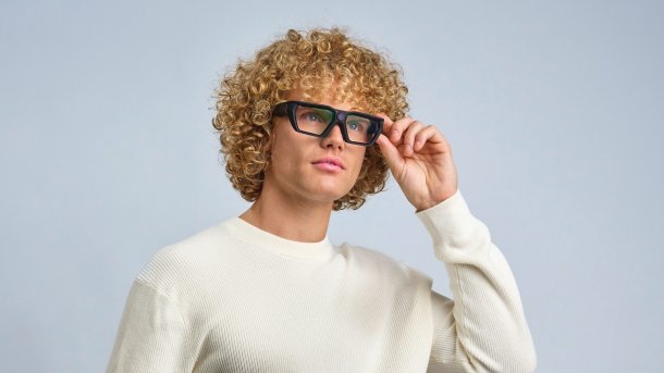 Man with blond curls and white jumper wearing VPS Next Smart Glasses.