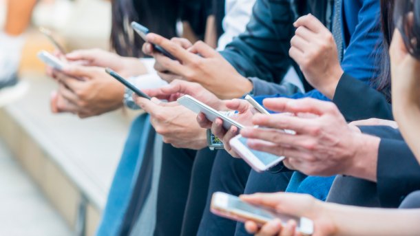 Viele Hände an Smartphones