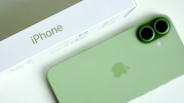 Grünes iPhone (von hinten) neben seiner Verpackung