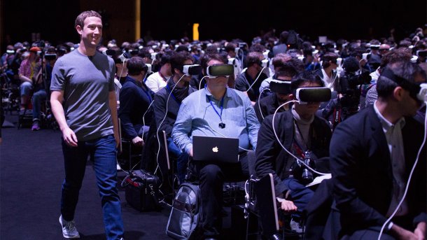 Mark Zuckerberg läuft an Messebesuchern vorbei, die Samsung Gear VR tragen.