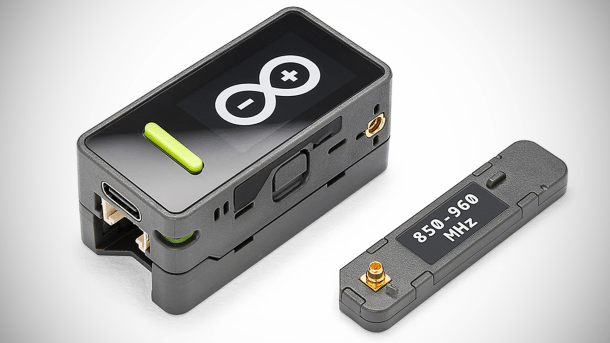 Man sieht den Arduino Nesso N1 in einem schwarzen Gehäuse. Im Gehäuse ist ein Display eingelassen. Neben dem Gerät liegt eine Antenne, die angeschraubt werden kann.