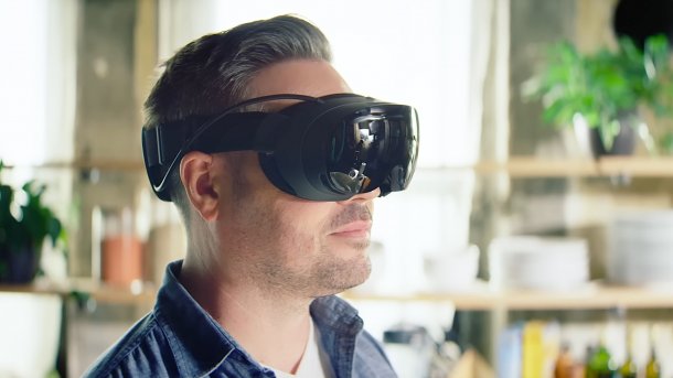 A man wearing a Steam Frame in the living room.