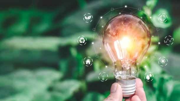 Hand,Holding,Light,Bulb,Ideas,On,A,Background,Of,Blurred