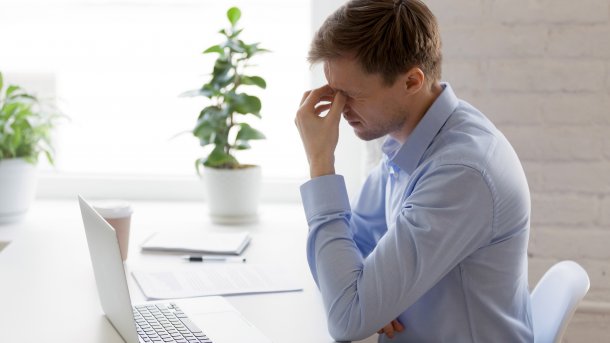 Tired man in front of a laptop
