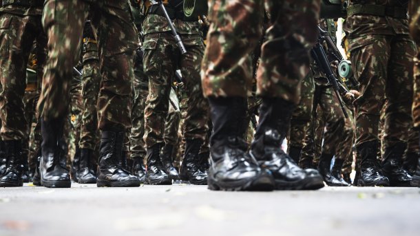 Boots and legs of soldiers in camouflage uniform