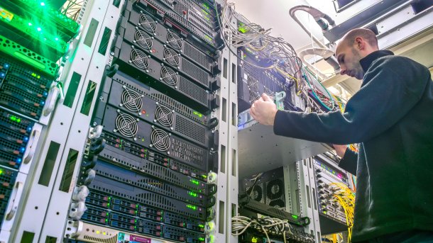 A technician installs new hardware in a server rack.