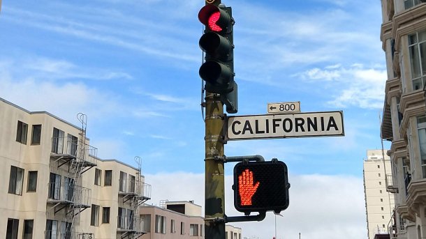 Red traffic light and red pedestrian crossing signal at an intersection on California Street in San Francisco
