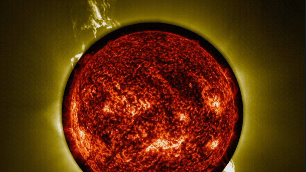 In roten Farben die Sonnenscheibe, die Korona darum in Gelbtönen und darin die Spur eines Ausbruchs