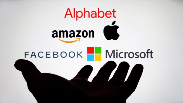 Schattige Hand vor einem Display mit Firmenlogos der Hyperscaler