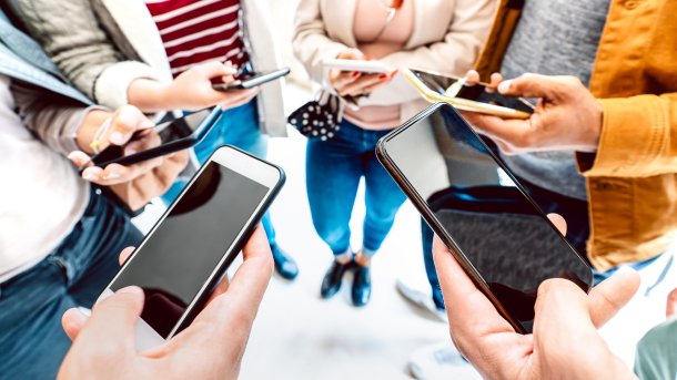 People standing in a circle with smartphones in their hands