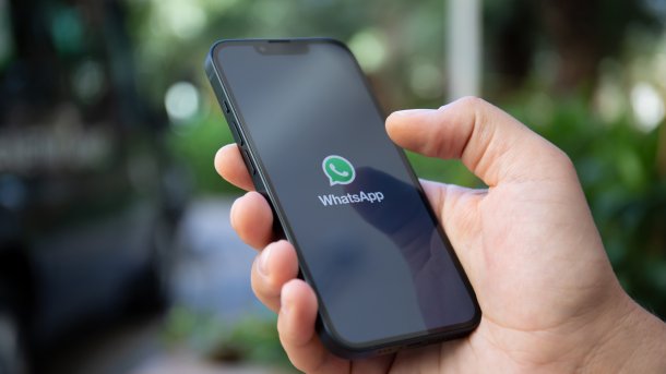 WhatsApp logo on a smartphone held in a hand.