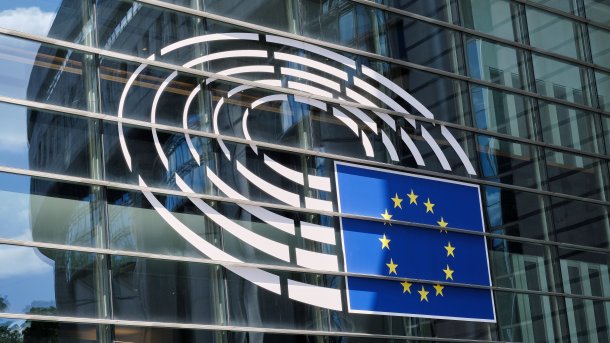 Glasfasse des Paul-Henri-Spaak-Gebäudes des Europäischen Parlamentsgebäudes in Brüssel mit 5 konzentrischen Ringen und dem Bild einer EU-Flagge