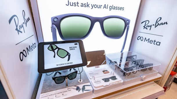 Ray-Ban Meta Smart Glasses in a store display with a demo tablet, product information, and the slogan “Just ask your AI glasses”.