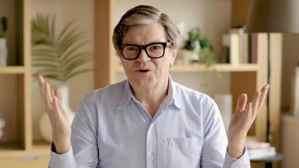 Yann LeCun spricht in einem Interview und gestikuliert mit erhobenen Händen vor einem Regal im Hintergrund.