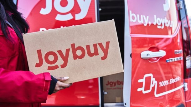 Person hält Paket mit Joybuy-Schriftzug – im Hintergrund Joyexpress Elektrotransporter 