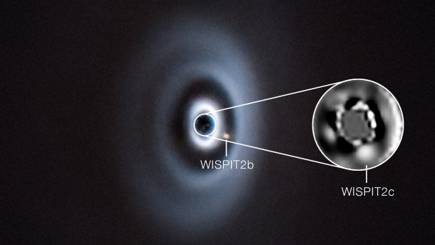 A round dust disk, enlarged two small dots in the gaps appearing there