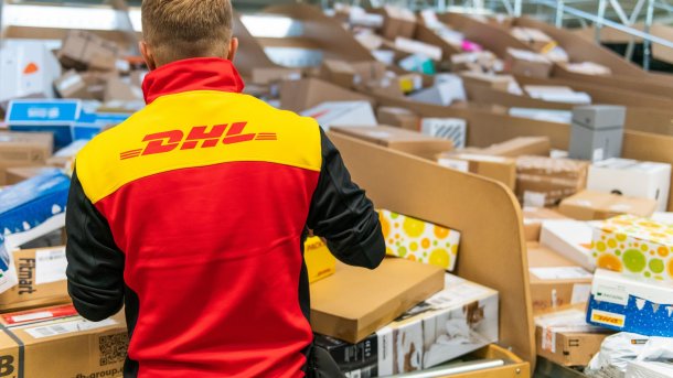 DHL-Mann sortiert Pakete