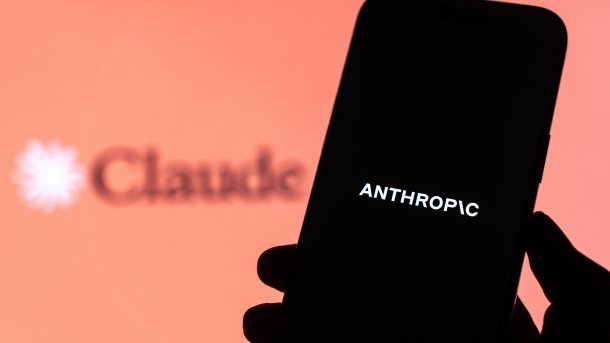 Anthropic steht auf einem Smartphone, im HIntergrund Claude. 