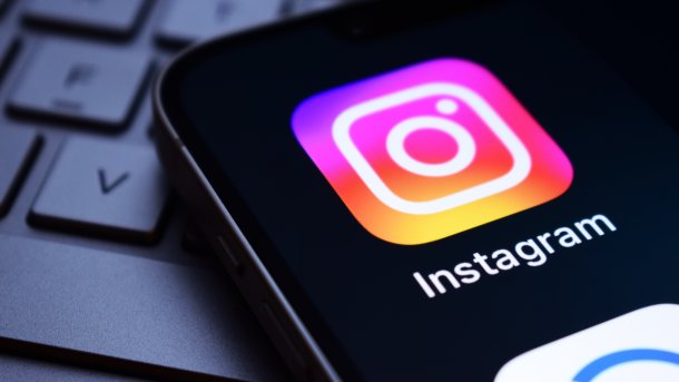 Smartphone display with Instagram logo, lying on a keyboard.