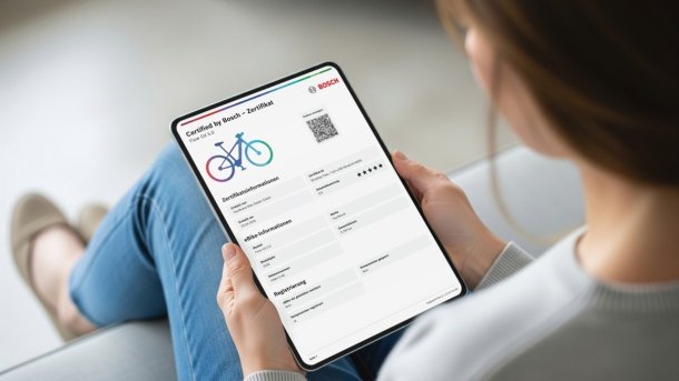 Woman with a tablet from the side rear, displaying a Bosch certificate.