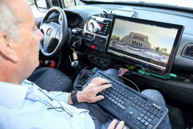 Mann auf Beifahrersitz mit Tastatur und Bildschirm