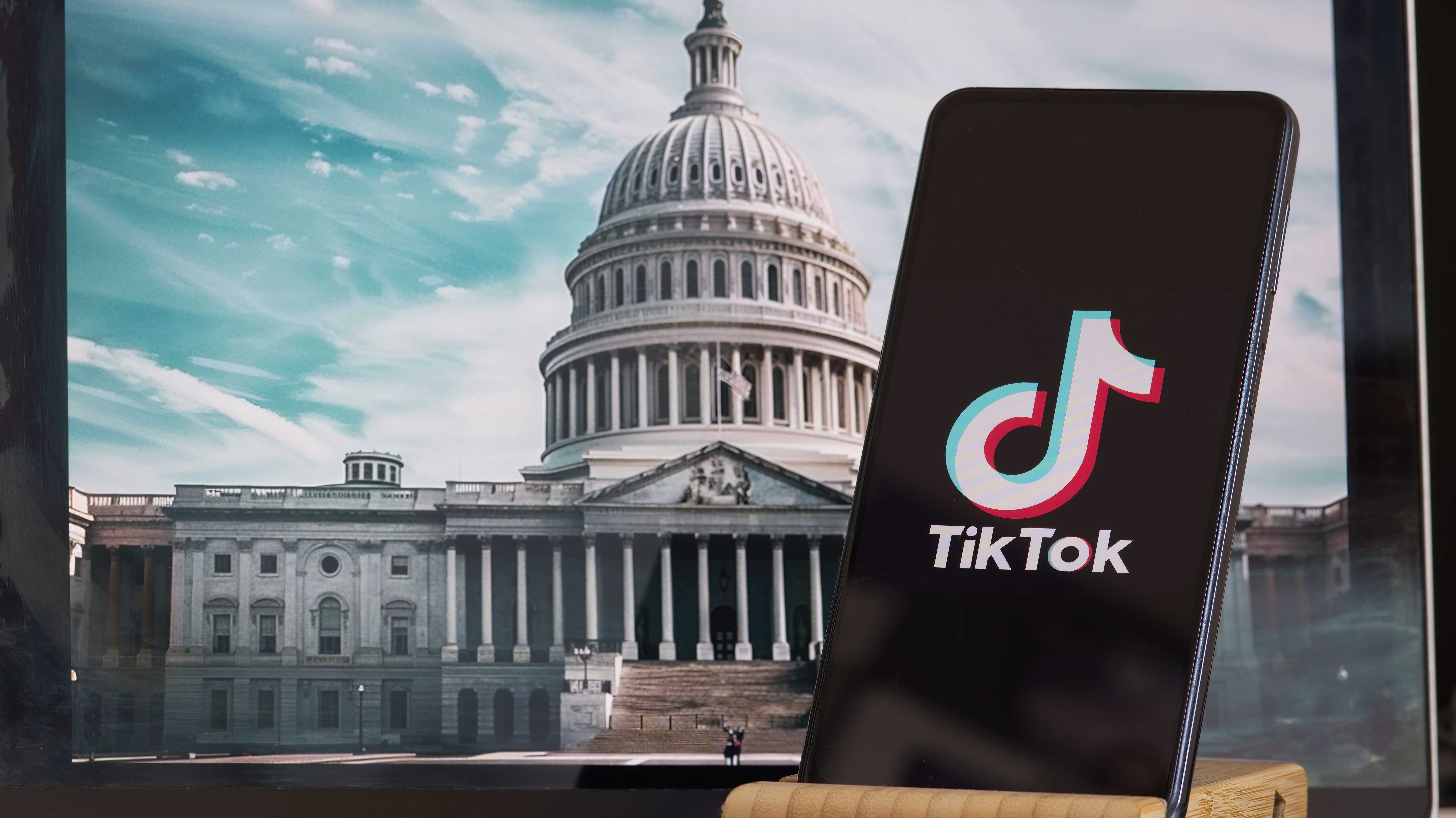 TikTok-Zeichen ist scharf im Vordergrund, während das Gebäude des American Congress im Hintergrund verwischt ist.