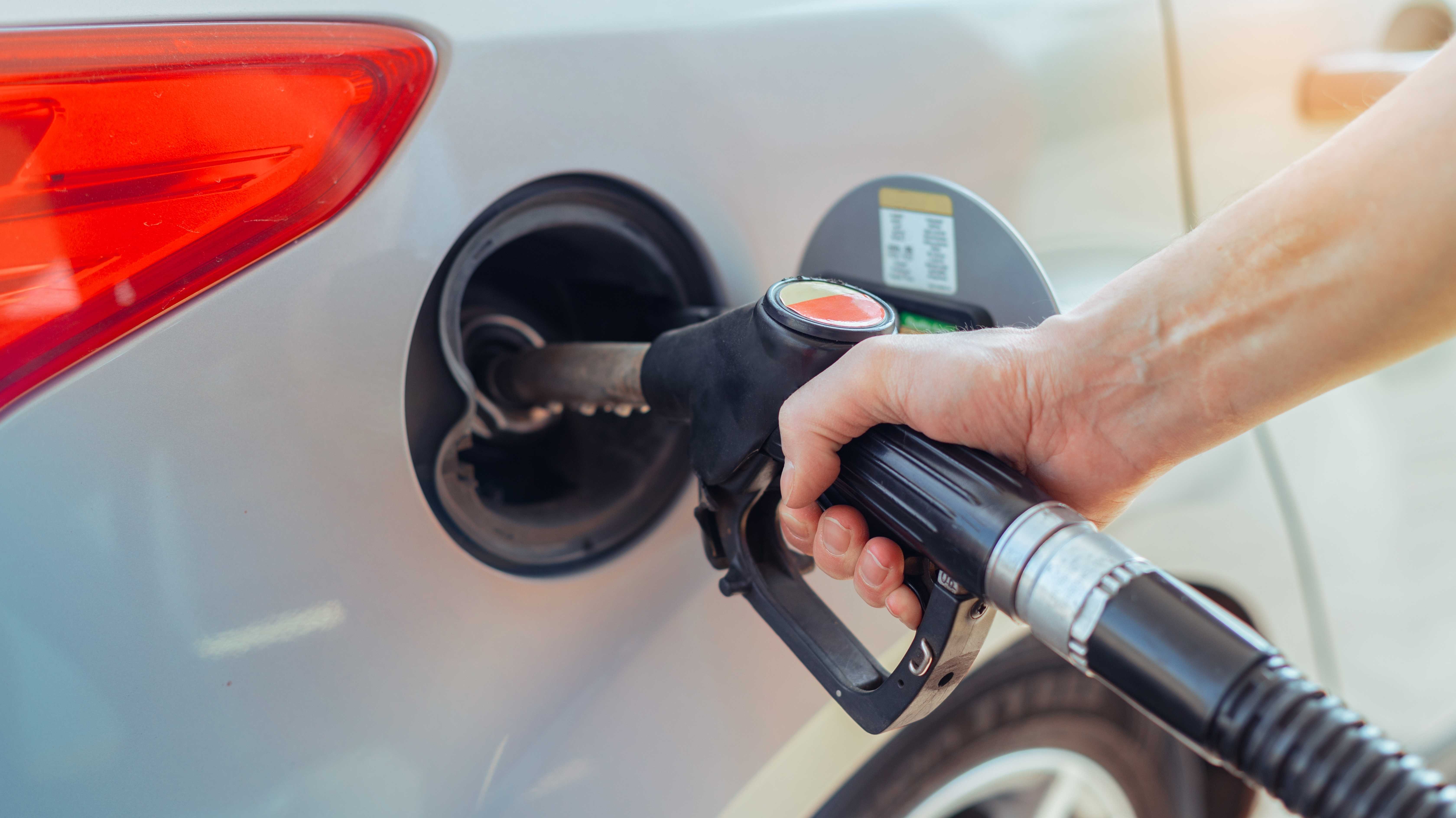 Tanken an einer Tankstelle. Mann tankt sein Auto von Hand.