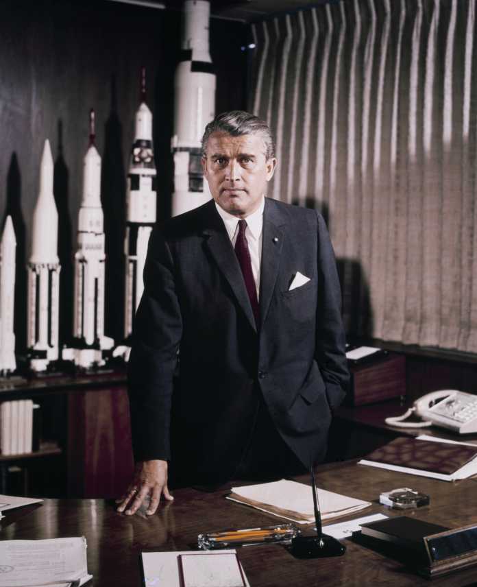 Wernher von Braun steht hinter Schreibtisch