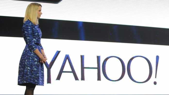 Marissa Mayer im Ganzkörperprofil neben Yahoo-Logo